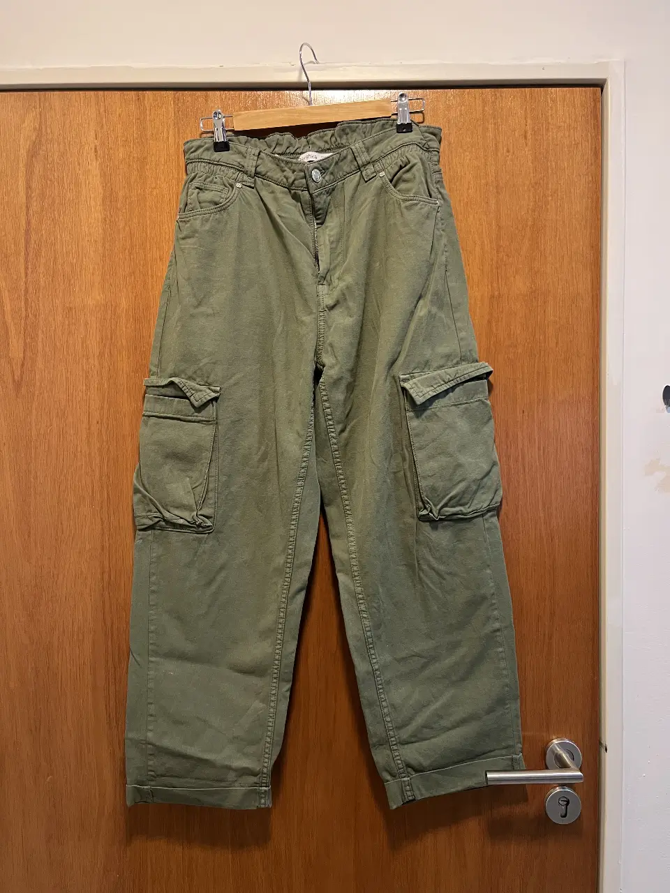 Pantalón cargo verde, con bolsillos laterales amplios y corte holgado. Ideal para un look utilitario y cómodo.