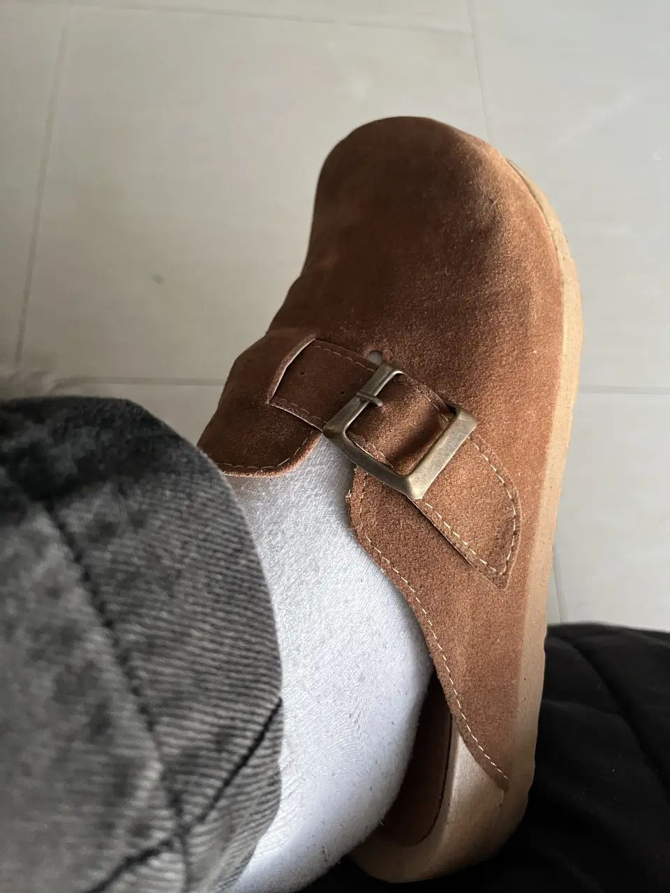 Zuecos de gamuza marrón con hebilla metálica. Ideales para un look casual y cómodo.