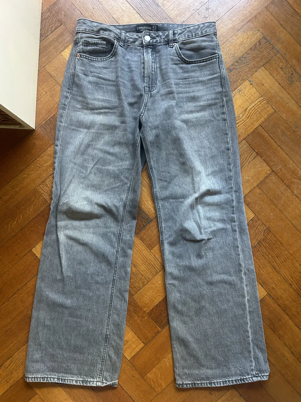 Jeans grises tiro alto, corte recto y pierna ancha. Un básico moderno para tu guardarropas, perfectos para combinar con todo.