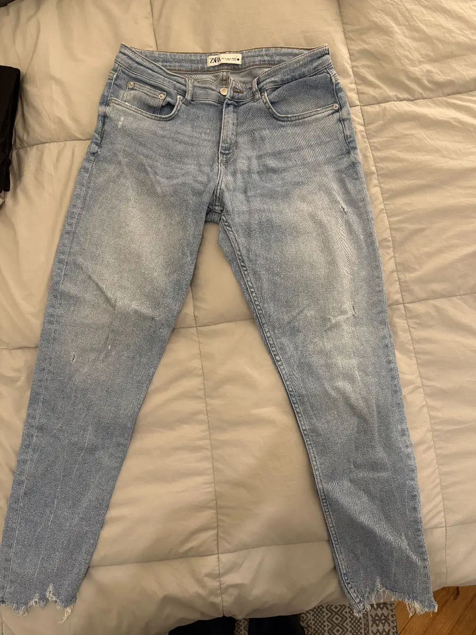 Jeans rectos de mujer, tiro medio, con detalles de roturas y desflecado en el bajo. Marca Zara, talle 42 Argentina, talle 10 USA.