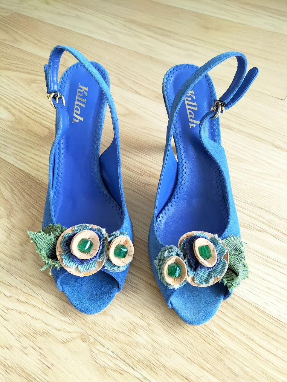 Sandalias de taco alto de gamuza color azul vibrante  con detalles de flores en corcho, arpillera verde y piedra en la punta  bca de pez. Tiras ajustables en el tobillo con hebilla dorada. Talle 39 o 38 horma holgada.Taco 8cm.  Perfectas para darle un toque chic a tu look.