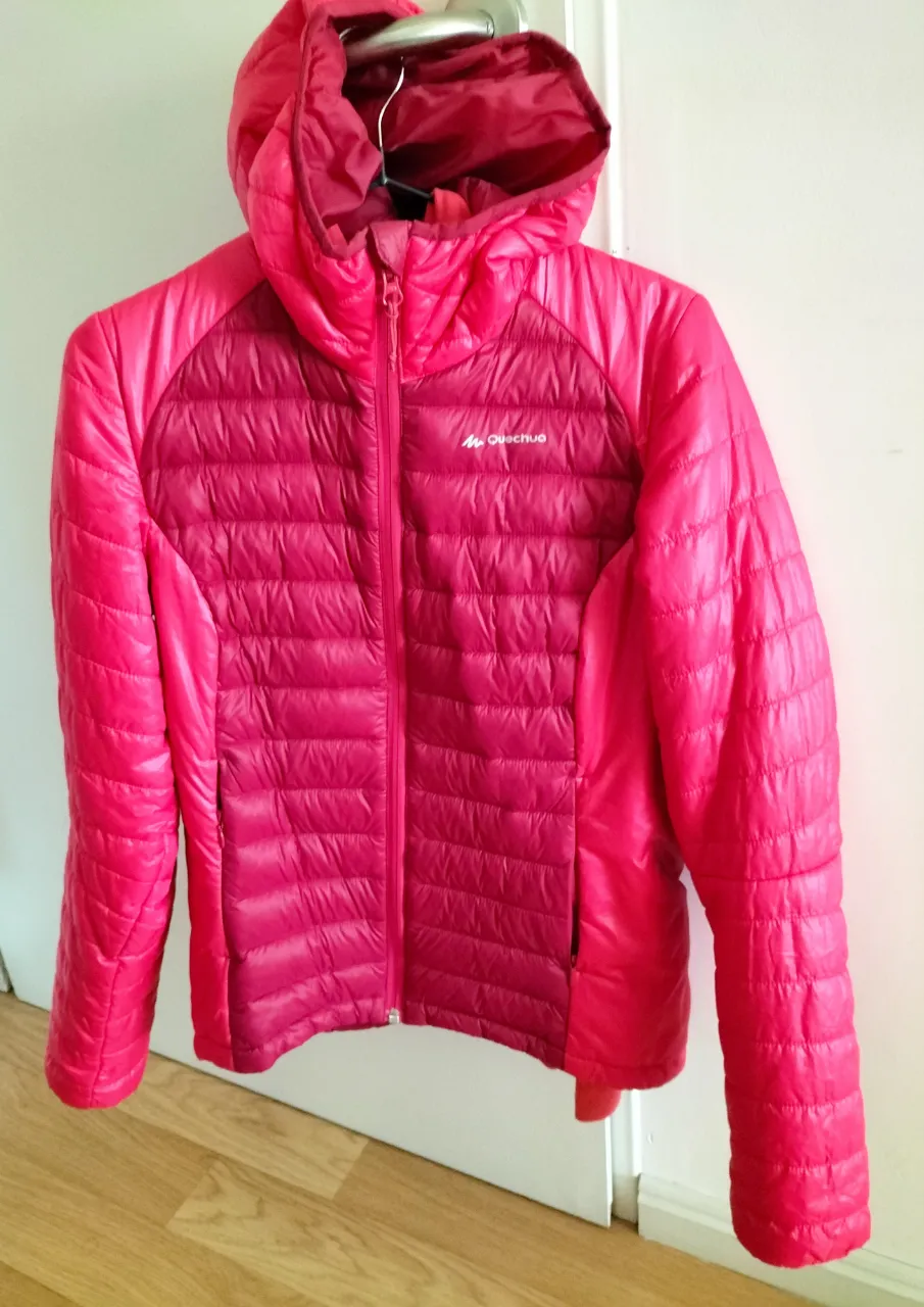 Campera acolchada fucsia, más oscuro en el centro. con capucha, ideal para el frío. Marca Quechua, perfecta para actividades al aire libre o para el día a día.