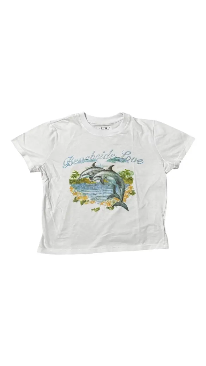 Remera blanca de manga corta con estampado "Beachside Love" con delfines y detalles de palmeras. Ideal para un look casual y playero.