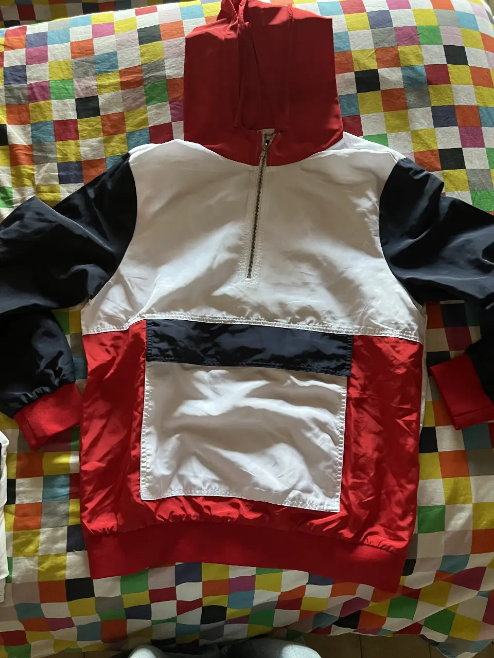 Buzo con cierre y capucha en colores blanco, negro y rojo. Ideal para un look deportivo y casual.