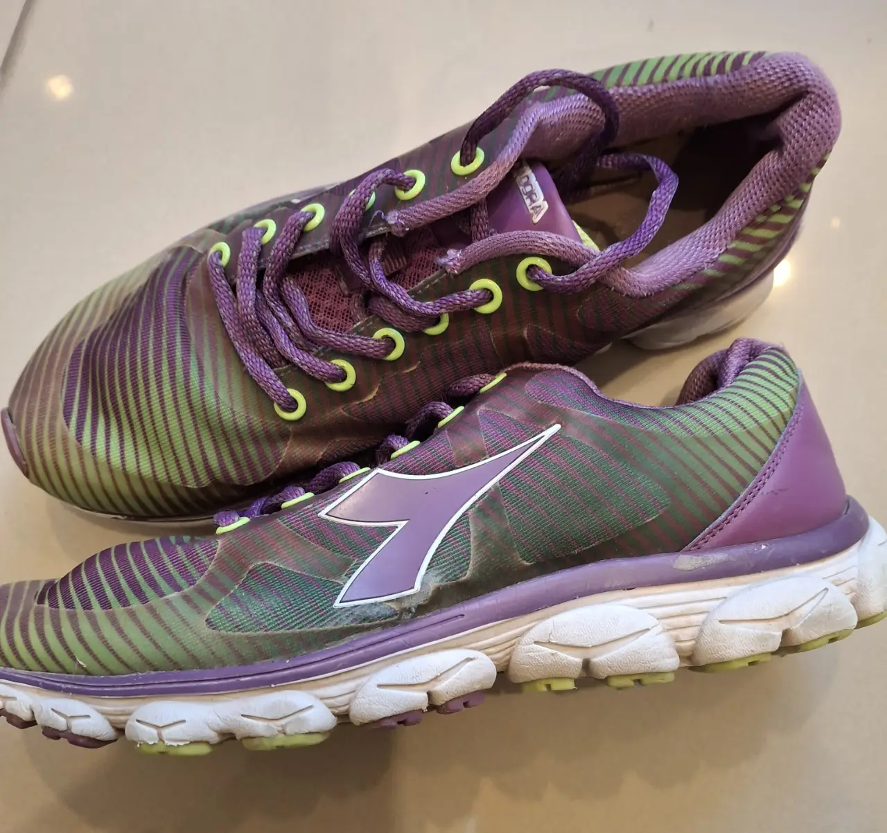 Zapatillas Diadora de mujer, color violeta y verde, con detalles en amarillo. Talle 38. Ideales para running y actividades deportivas.
