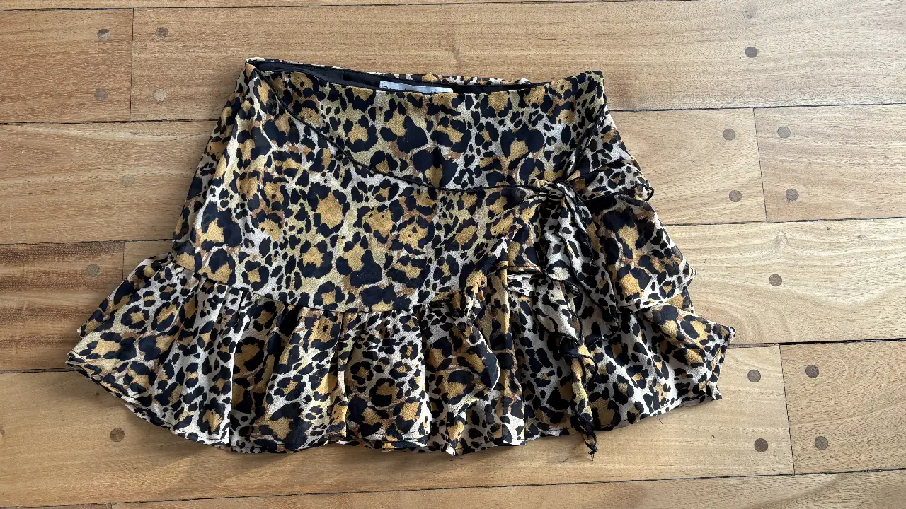 Pollera mini con estampado de leopardo, con volados y detalle de lazo. Marca Bershka, talle S.