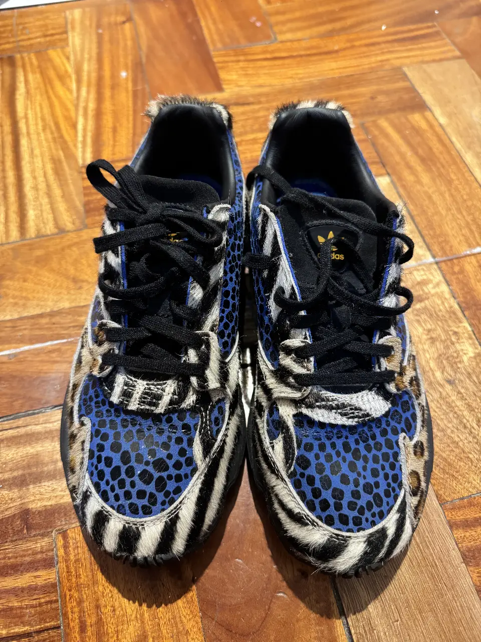 Zapatillas Adidas Falcon con estampado animal print, detalles en azul y negro. Diseño moderno y llamativo, ideales para un look urbano y con estilo.