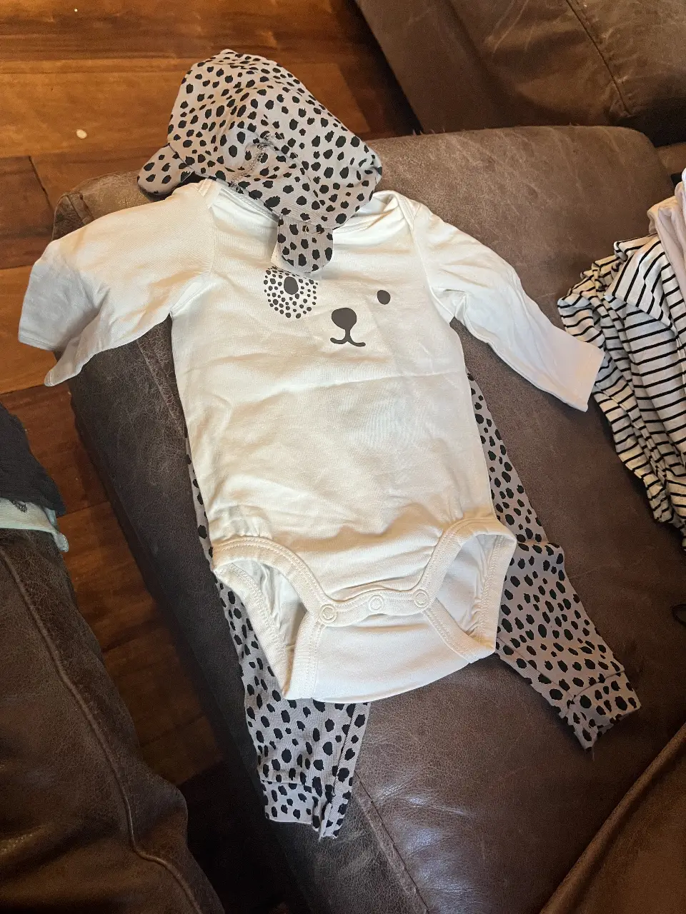Body de bebé blanco con estampado de oso y pantalón con diseño de lunares. Incluye gorro a juego.