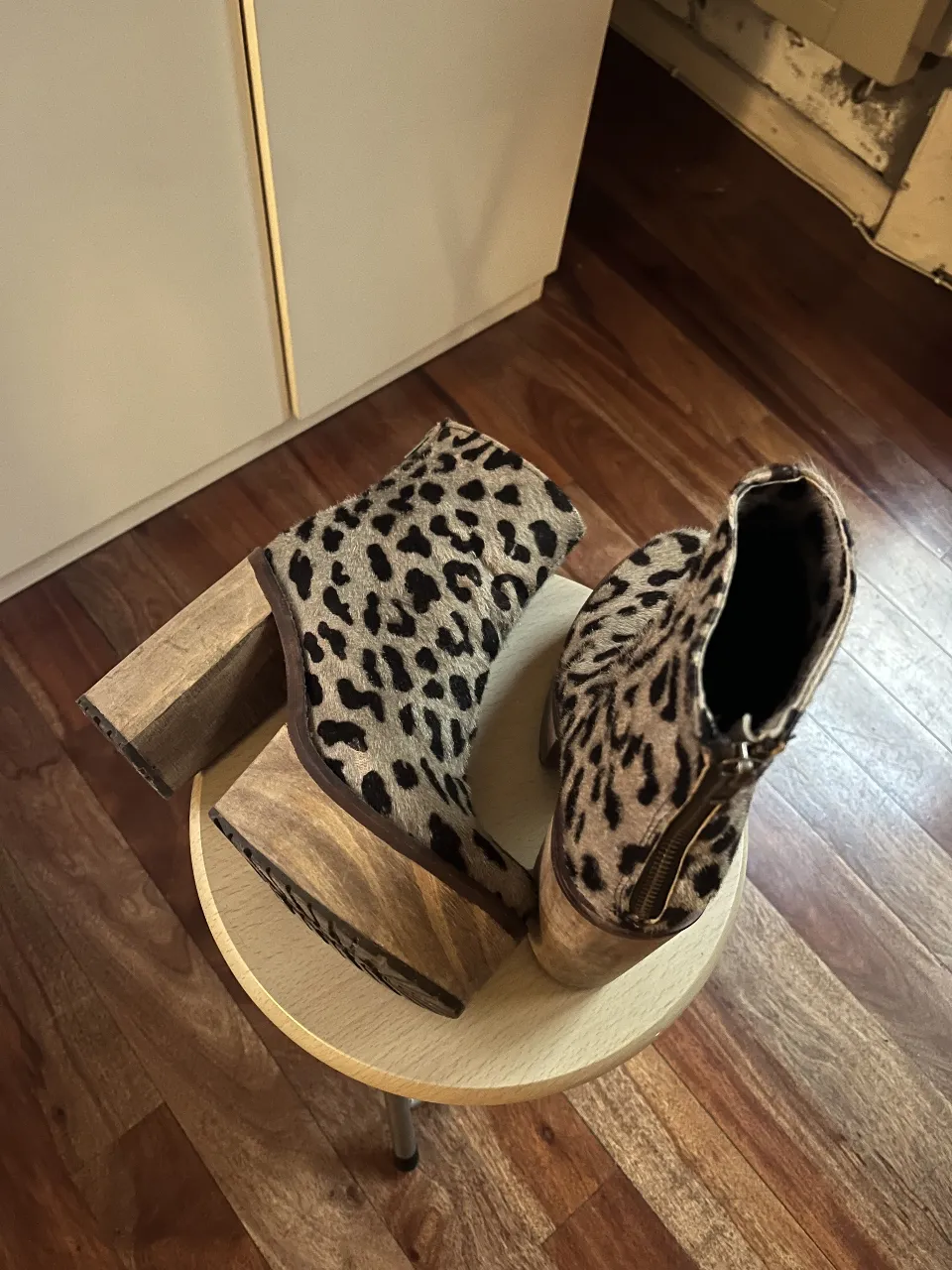 Botas de mujer con estampado de leopardo, taco de madera y cierre atras. Ideales para un look moderno y audaz.