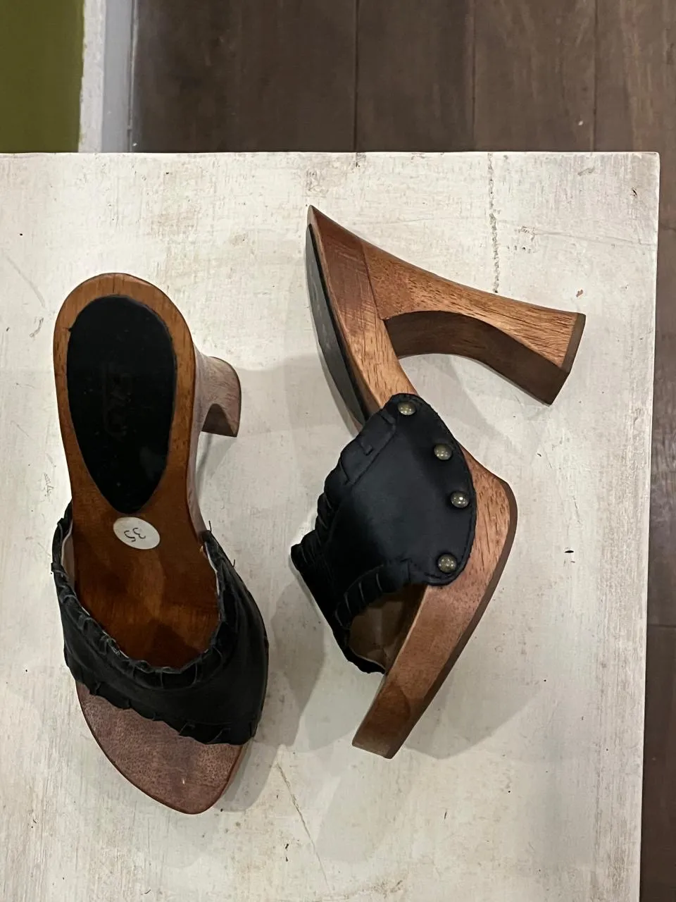 Zuecos de madera con detalles en cuero negro . Ideales para un look vintage y cómodo.