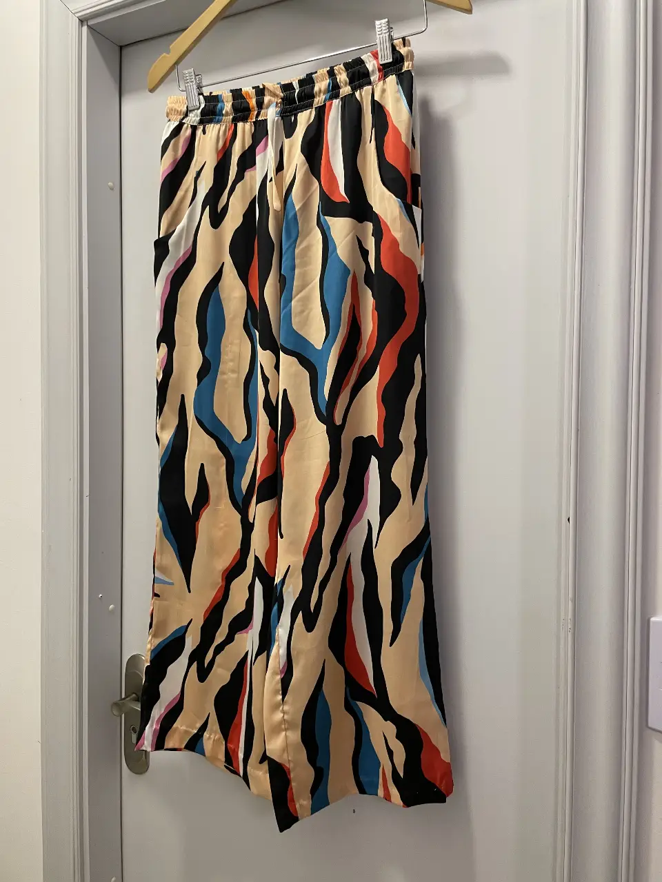 Pantalón suelto de mujer con estampado abstracto en tonos beige, azul, rojo y negro. Talle M/M de la marca Casa Chic. Ideal para un look casual y moderno.