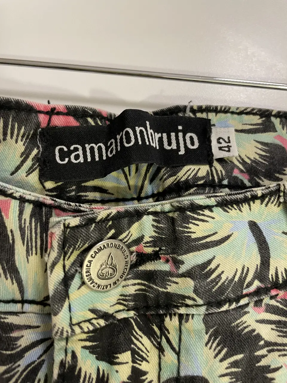 Jeans rectos con estampado de hojas tropicales. Marca Camaronbrujo, talle 42. Ideal para un look casual y canchero.