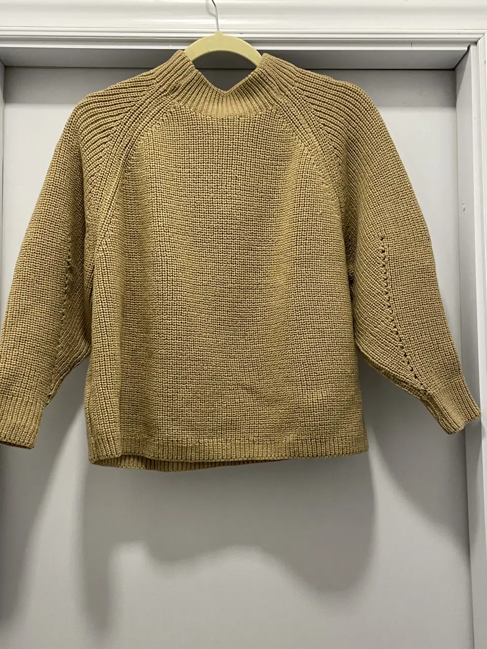 Sweater de cuello alto en color camel, tejido grueso y detalles en las mangas. Ideal para un look casual y abrigado.