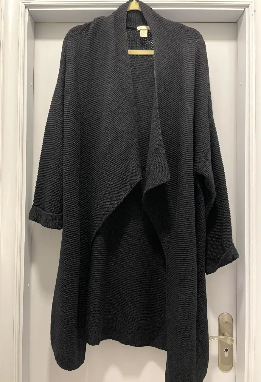 Cardigan negro de tejido grueso, con solapas amplias y mangas largas. Ideal para un look casual y abrigado.