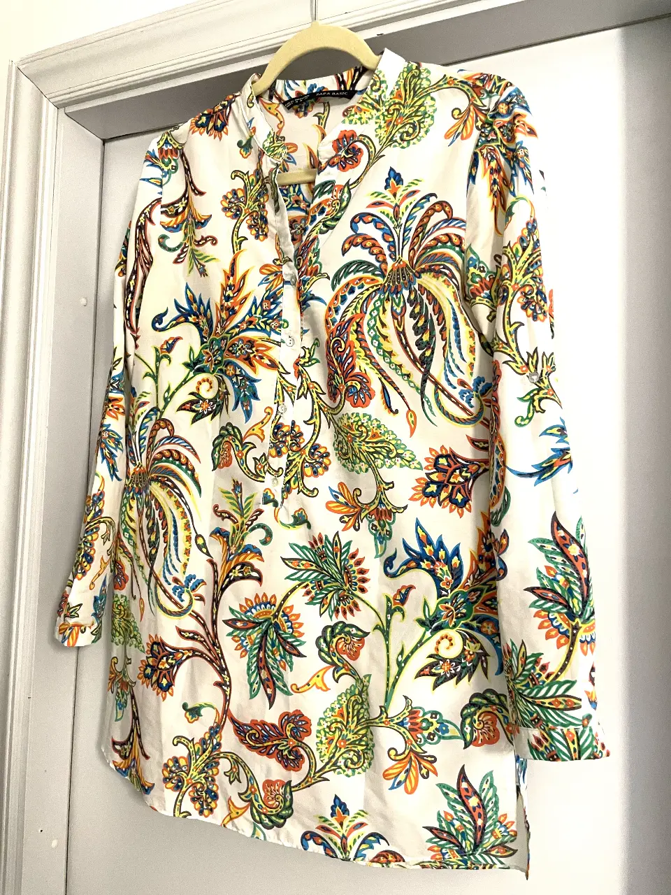 Blusa de mujer con estampado floral en tonos vibrantes. Confeccionada en una mezcla de algodón y acetato, esta camisa de manga larga presenta un diseño elegante y cómodo. Ideal para un look casual con un toque de sofisticación.