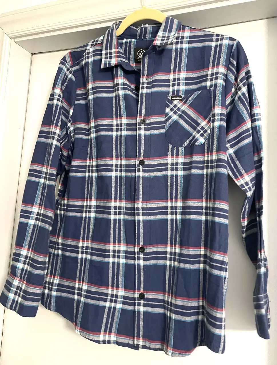 Camisa a cuadros azul y blanca de hombre, manga larga, con bolsillo en el pecho y logo de la marca Volcom. Ideal para un look casual y cómodo (XL NIÑO)