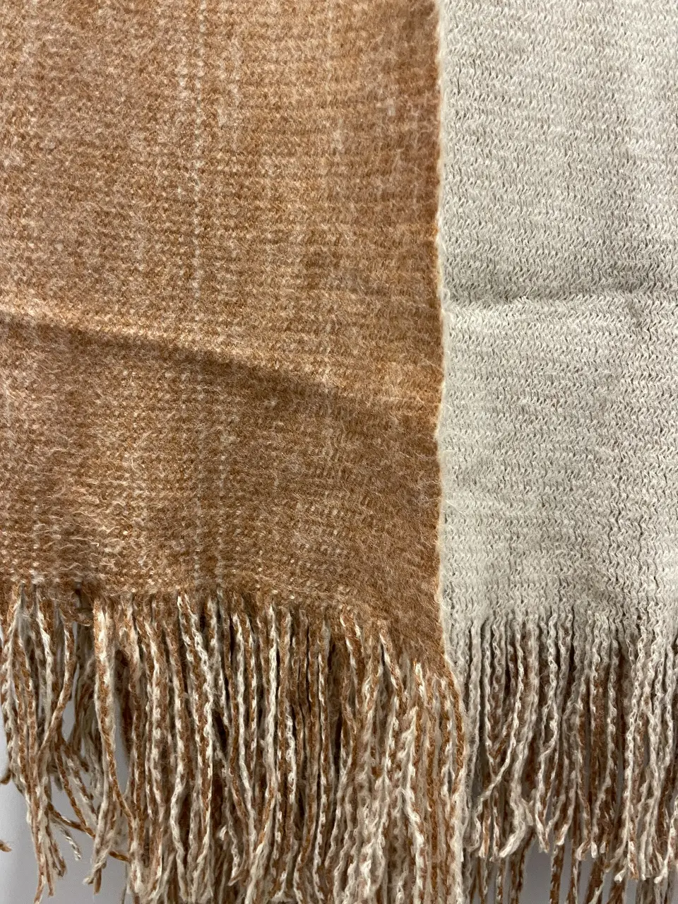 Bufanda de tejido grueso en tonos marrones y crudos, con flecos en los extremos. Ideal para abrigarte con estilo en los días fríos.