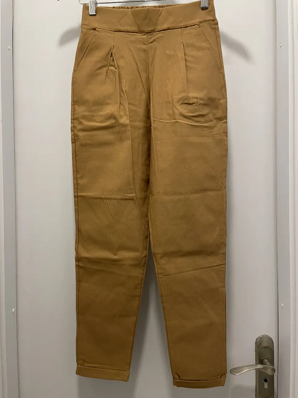 Pantalón sastrero color camel, con pinzas y cintura elastizada. Talle 26.