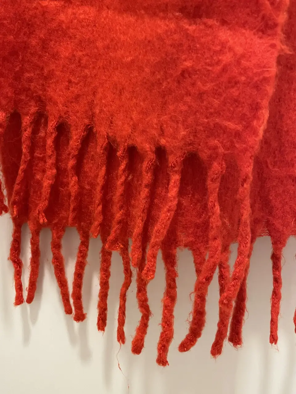 Bufanda roja de tejido grueso y suave, ideal para abrigarte con estilo en los días fríos. Perfecta para complementar cualquier look de invierno.