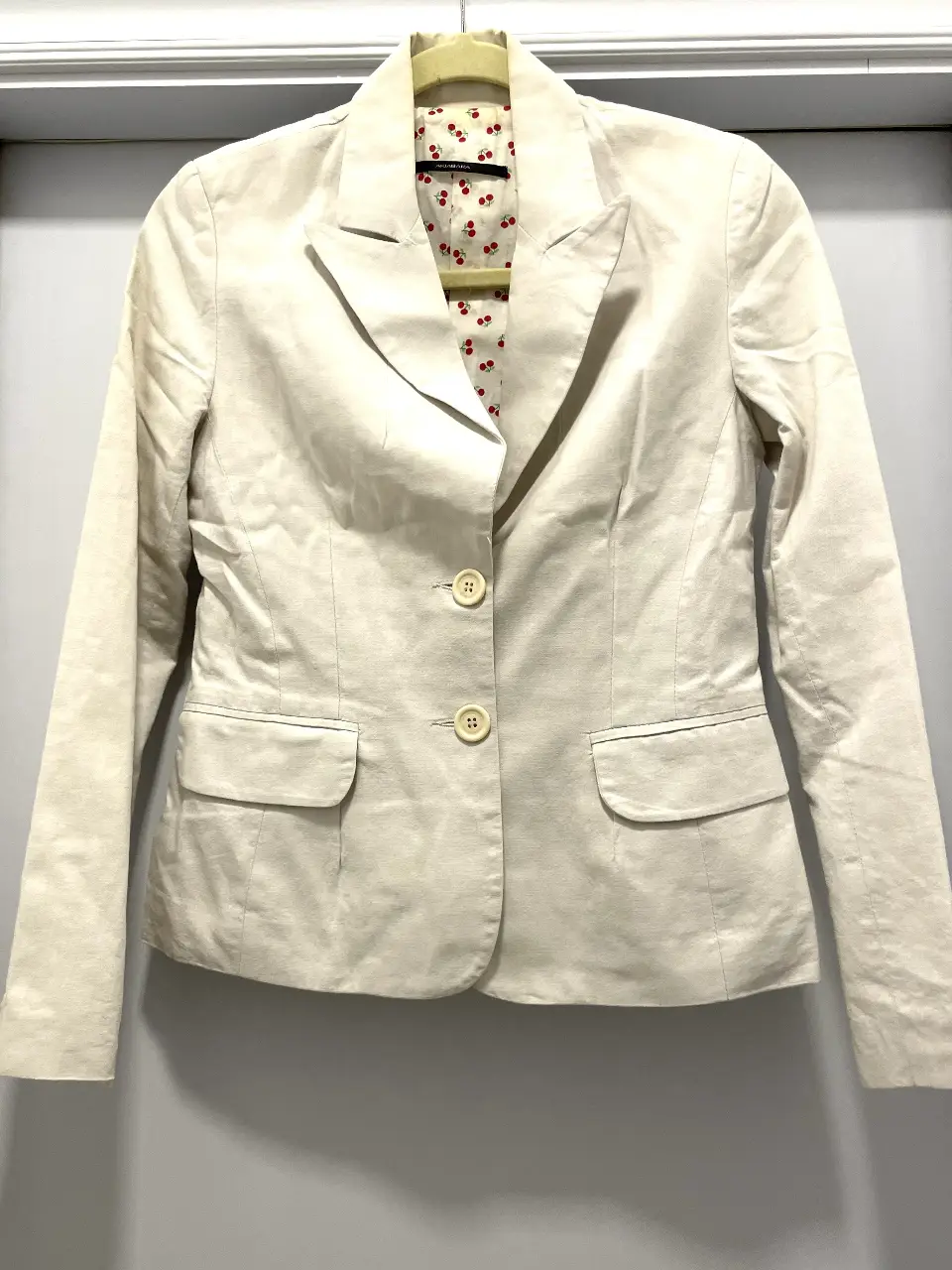 Blazer de mujer color crudo, con forro interior estampado con cerezas. Confeccionado en 100% algodón, ideal para un look elegante y versátil. Última foto marca un detalle.