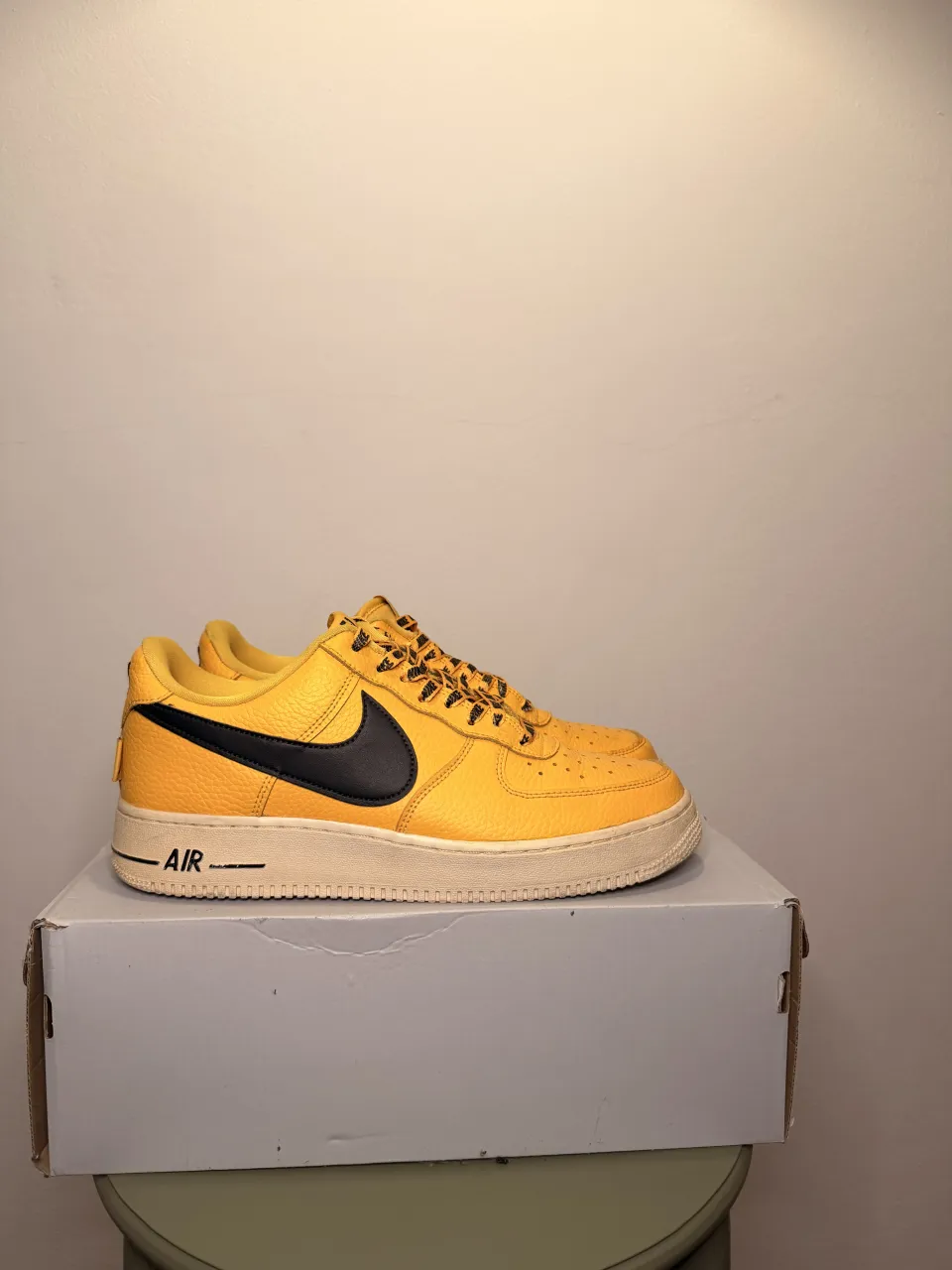 Zapatillas deportivas color amarillo con detalles en negro. Logo de la marca en los laterales y en la lengüeta. Inscripción "AIR" en la suela.