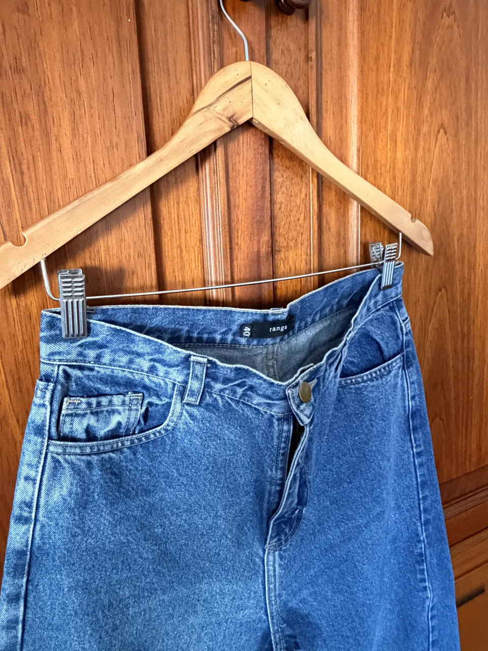 Jean de tiro alto con roturas en los bajos. Cierre con botón.