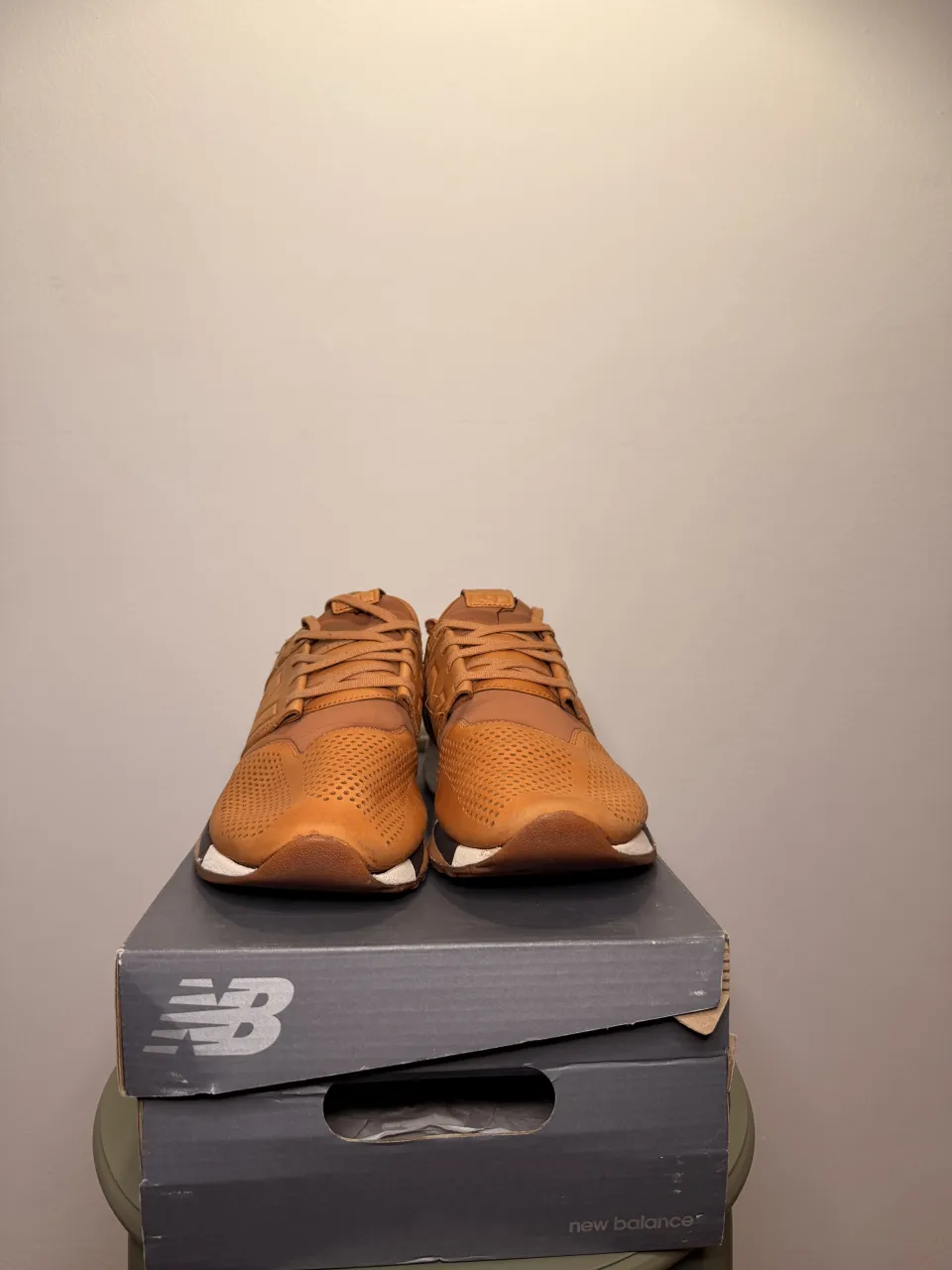 Zapatillas de cuero color marrón con detalles en negro y suela blanca. Presentan perforaciones en la capellada y el logo de la marca en los laterales.