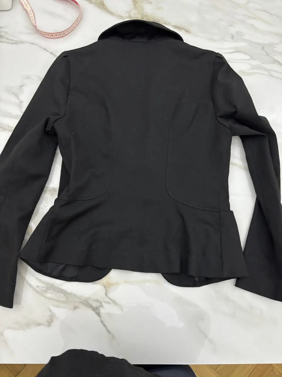 Blazer negro de mujer, entallado, con solapas y corte en la cintura. Ideal para un look formal o de trabajo.