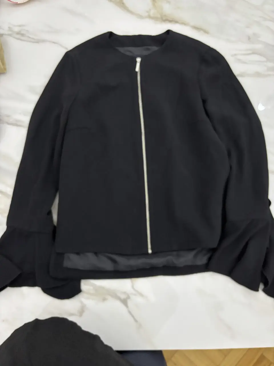 Chaqueta negra de Zara Basic Collection, con cierre y mangas acampanadas. Ideal para un look elegante y moderno.
