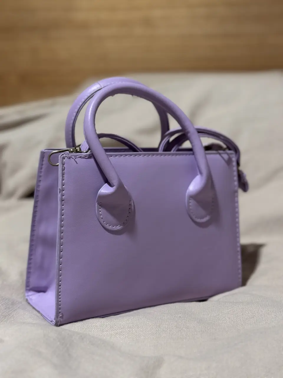 Cartera de mano rectangular en color lila. Ideal para llevar lo esencial con estilo. Perfecta para complementar cualquier look.