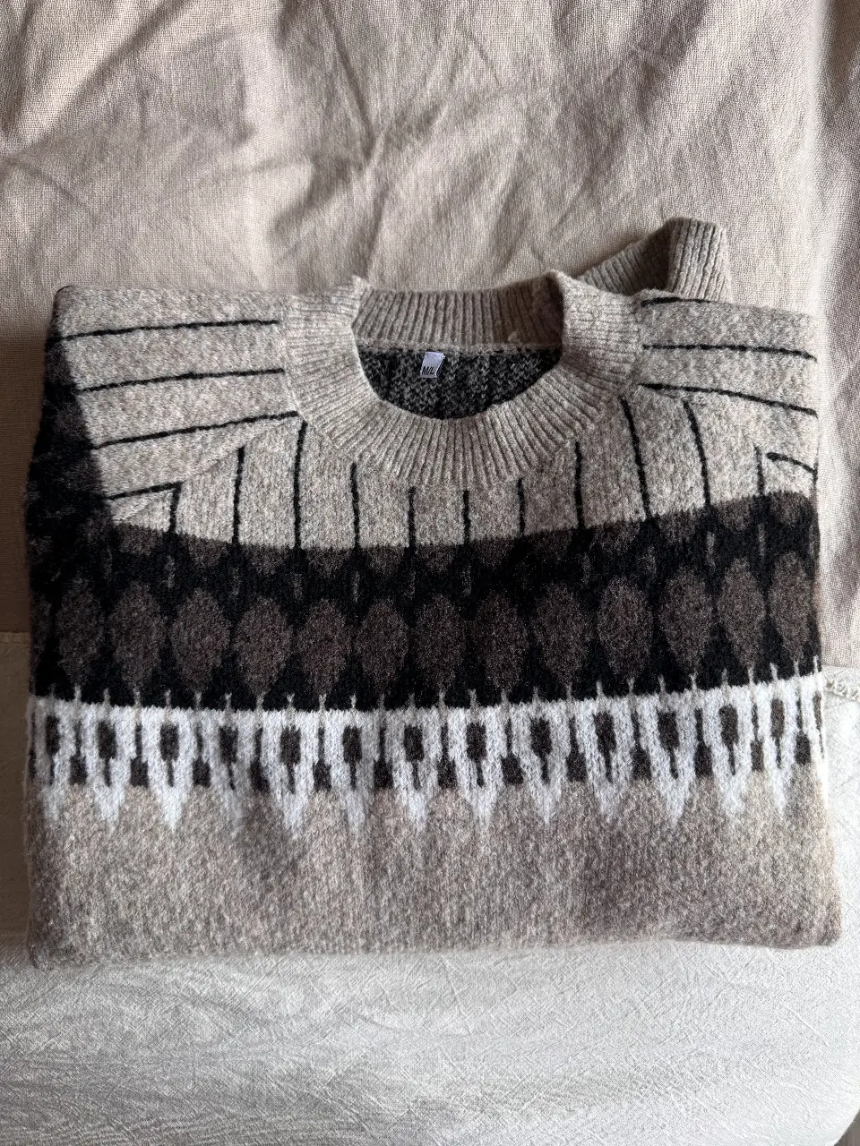 Sweater de lana con diseño geométrico en tonos neutros. Ideal para un look casual y abrigado en invierno. 