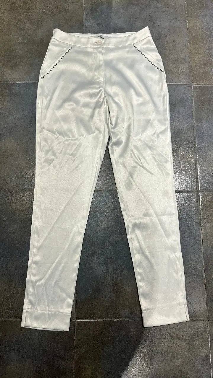 Pantalón sastrero blanco satinado con detalles de strass en los bolsillos. Ideal para un look elegante y sofisticado. Marca Zhoue
