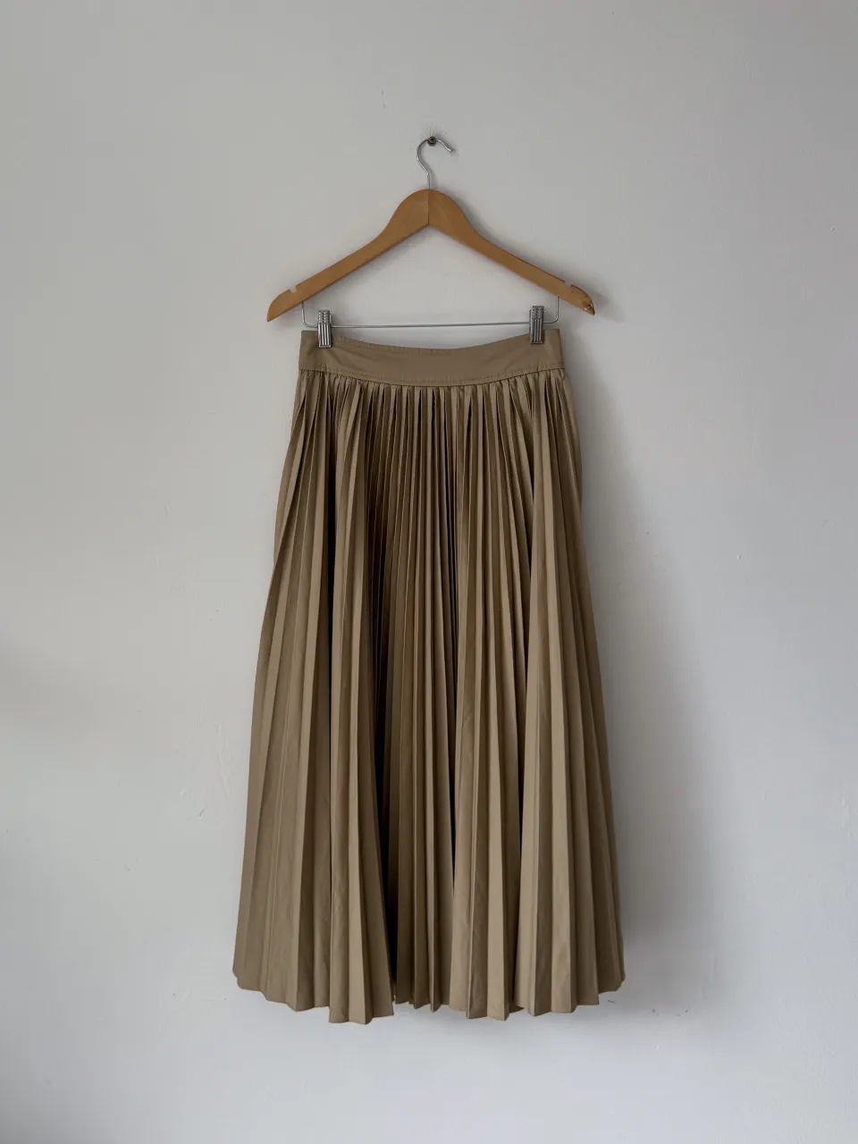 Pollera larga de color beige con pliegues.