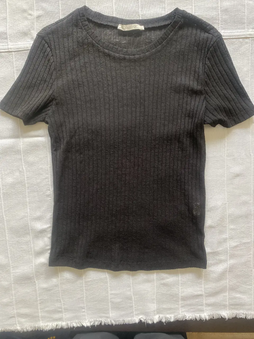 Remera de manga corta negra de Zara Trafaluc, ideal para un look casual y versátil. Confeccionada en tejido de punto, ofrece un ajuste cómodo y favorecedor. Perfecta para combinar con jeans o faldas.