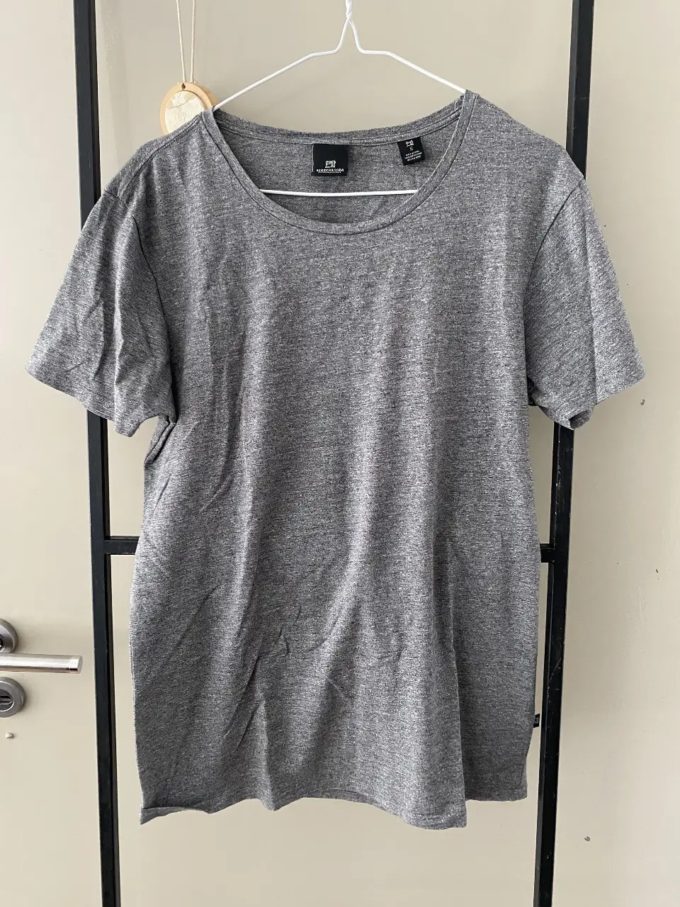 Remera gris de hombre, de manga corta, con cuello redondo. Ideal para un look casual y cómodo.