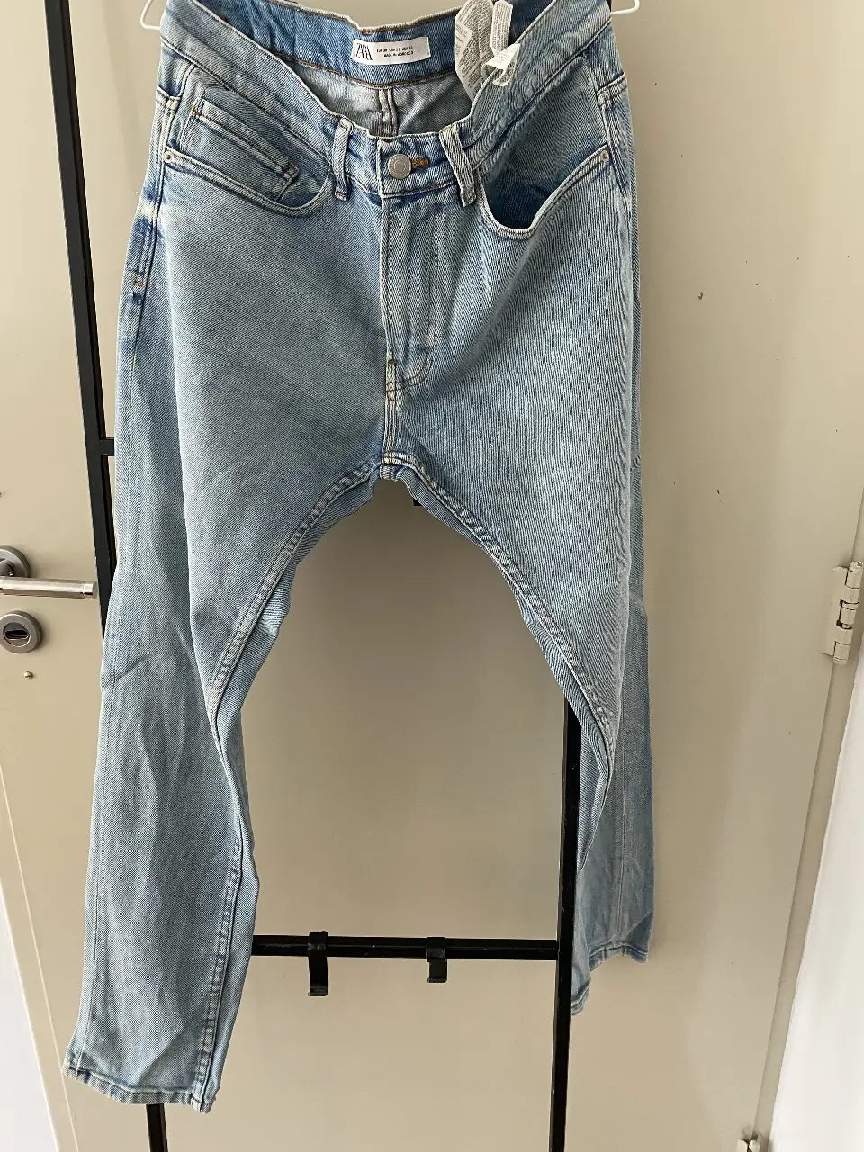 Jeans rectos de hombre, tiro medio, de la marca Zara. Talle usa 30, con detalles de desgaste y roturas.