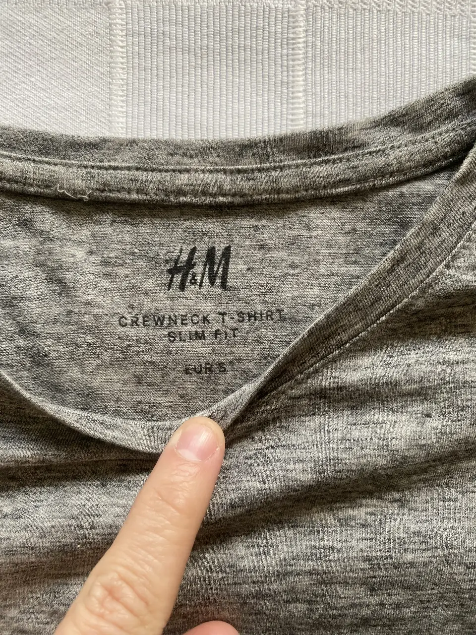 Remera de hombre H&M, cuello redondo, corte slim fit, color gris jaspeado. Ideal para un look casual y cómodo.