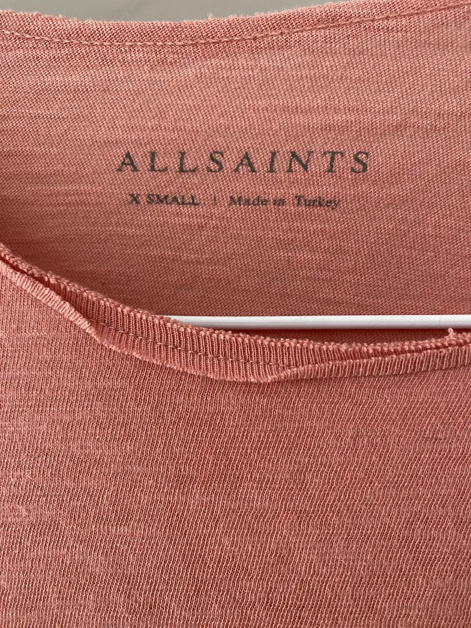 Remera de manga corta color rosa, de la marca Allsaints. Talle XS. Ideal para un look casual y cómodo.