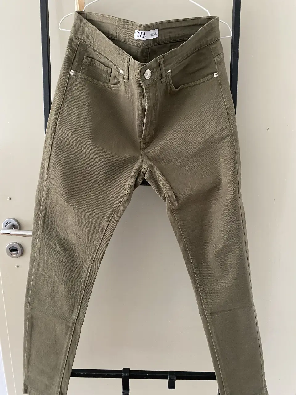 Jeans rectos de hombre color verde militar de la marca Zara. Talle 32, con etiqueta de cuero en la parte trasera.