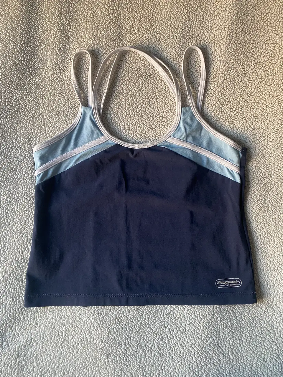 Musculosa deportiva Reebok Gym, con diseño en dos tonos de azul y tiras blancas. Ideal para entrenamientos. talle m/l