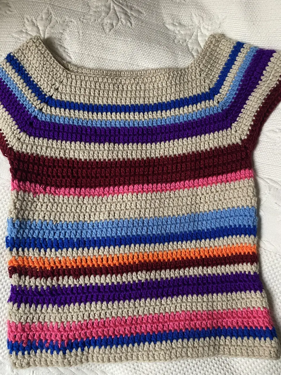 Top tejido a crochet con diseño a rayas multicolores. Ideal para un look artesanal y bohemio.