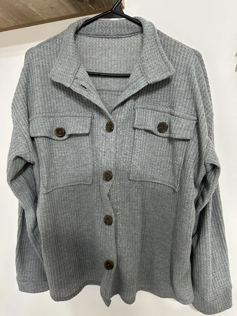 Camisa tipo shacket gris con diseño de waffle, ideal para un look casual y abrigado. Cuenta con botones y bolsillos delanteros.