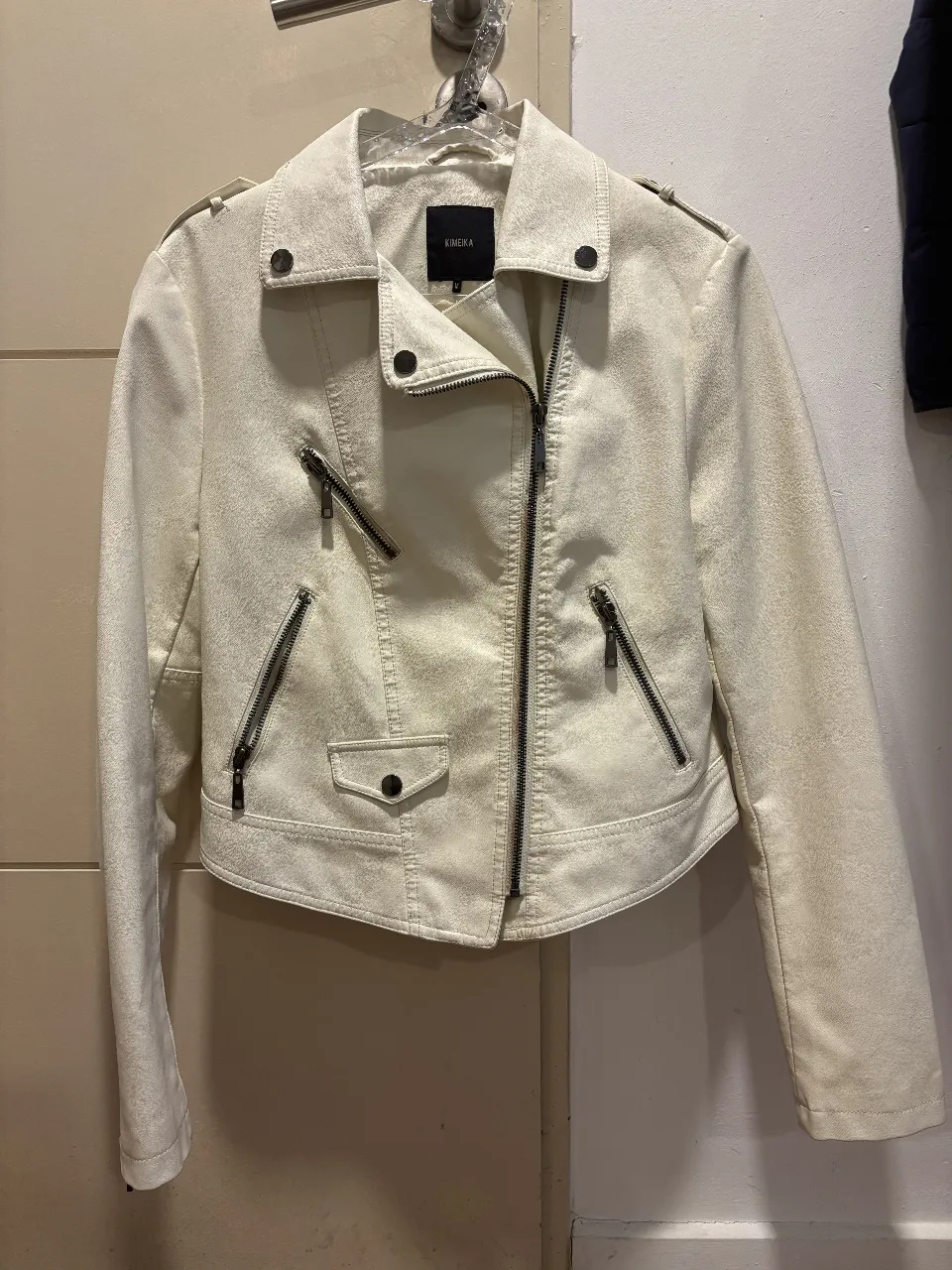 Campera de cuero sintético color blanco, con cierre asimétrico y detalles de diseño. Ideal para un look moderno y audaz.