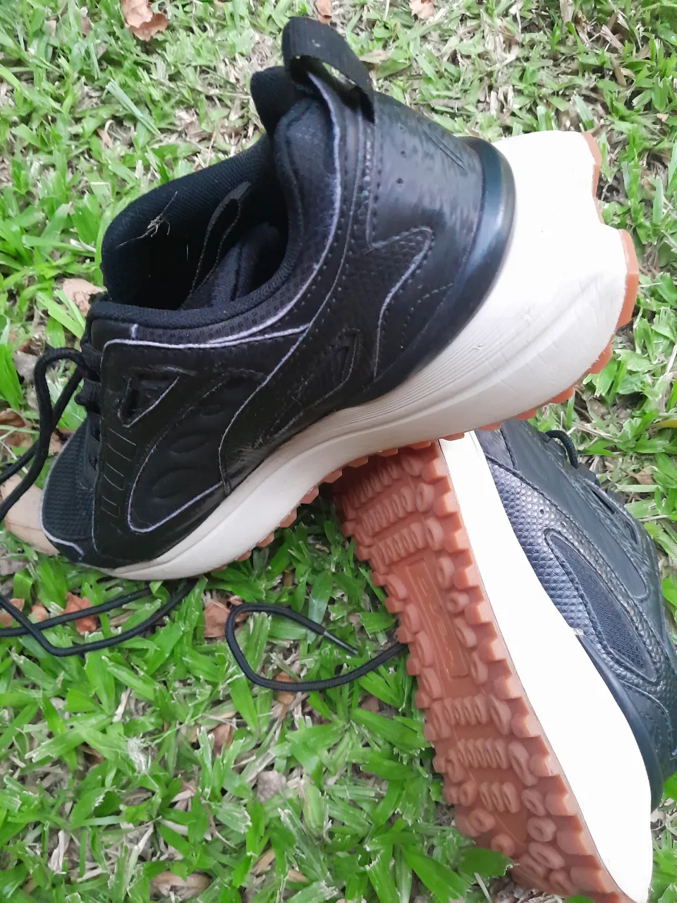 Zapatillas deportivas negras con suela de goma color caramelo. Cordones negros.