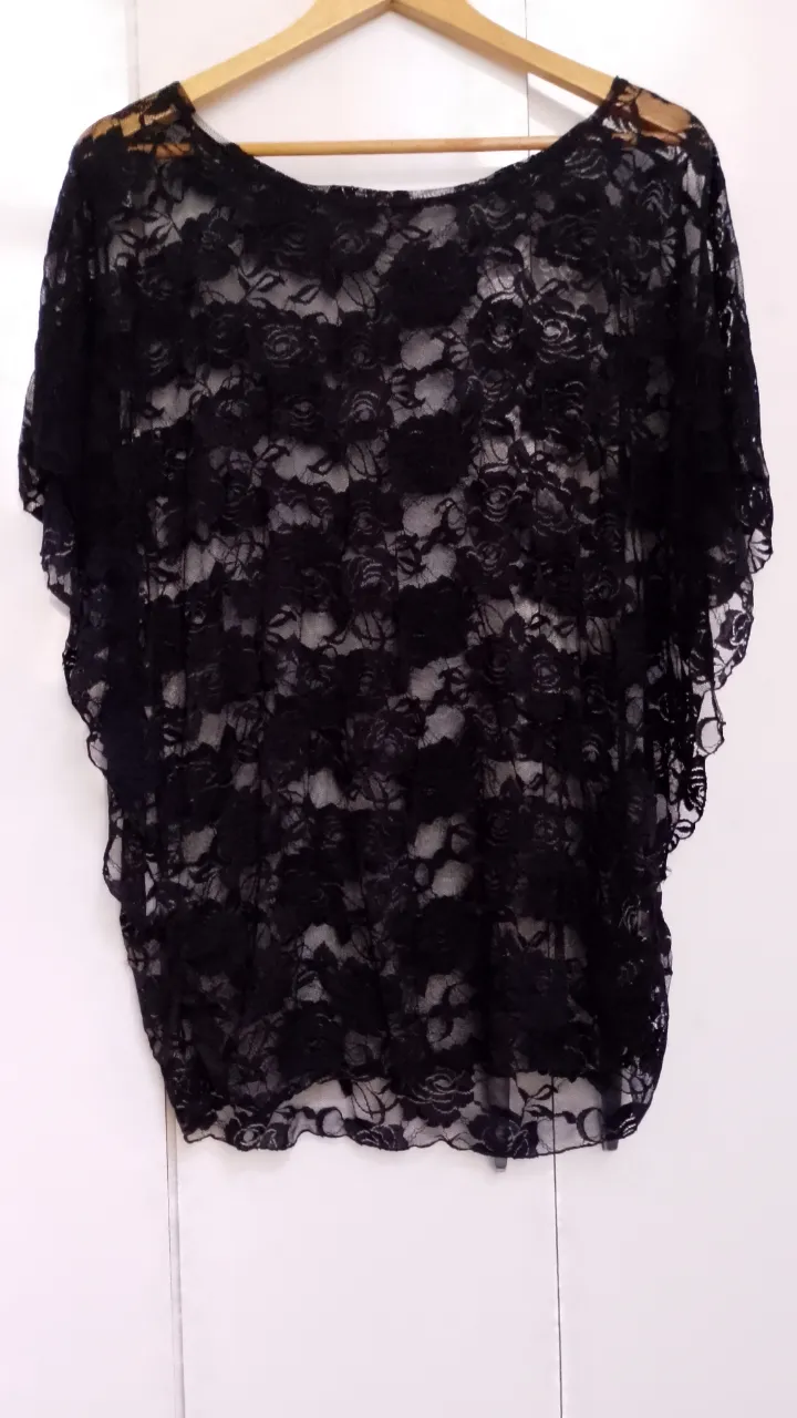 Blusa de encaje negra con mangas cortas y escote redondo.