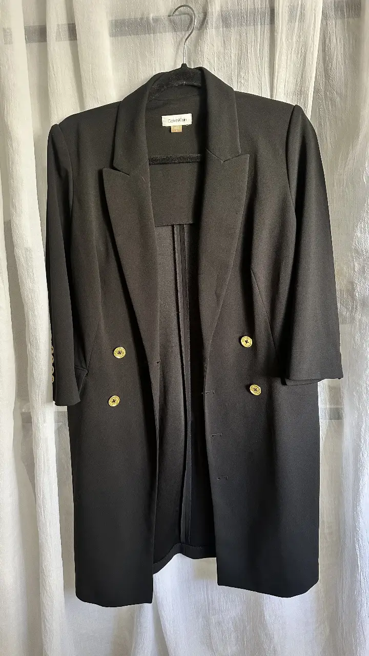 Elegante blazer negro de Calvin Klein, ideal para un look formal o de trabajo. Confeccionado en un tejido de calidad, este blazer de corte clásico presenta un diseño de doble botonadura y mangas 3/4, perfecto para combinar con diferentes outfits.