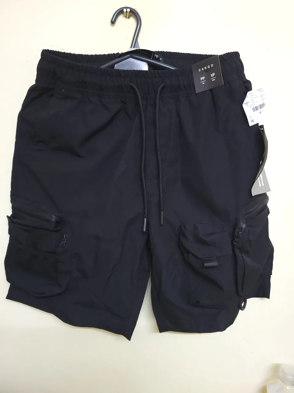Short de hombre tipo cargo, de color negro. Posee bolsillos laterales con cierre y cintura elastizada con cordón. Ideal para un look casual y urbano.