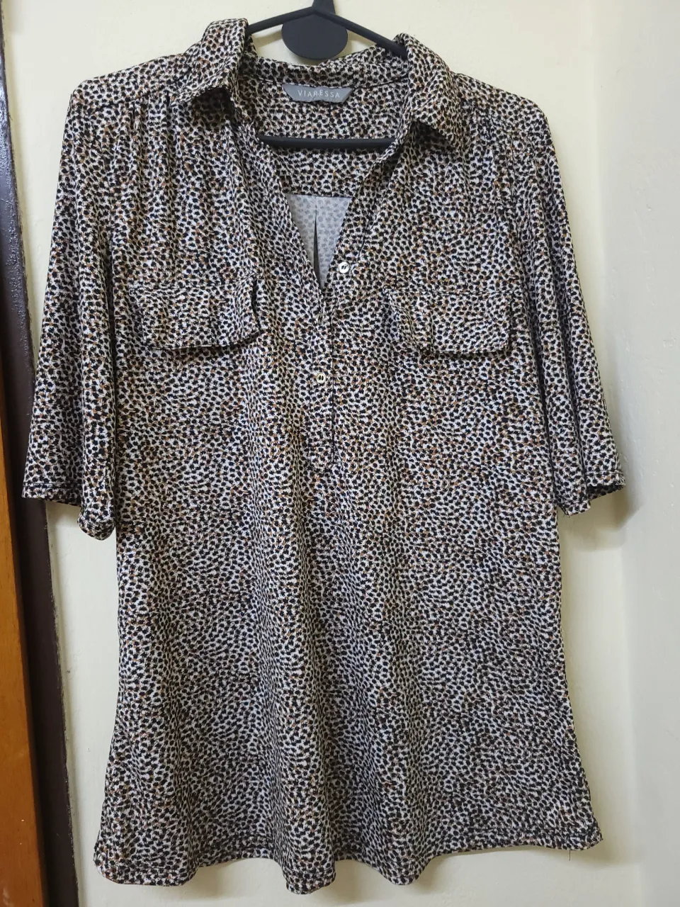Blusa de mujer con estampado de lunares en tonos marrones y blancos. Cuello camisero y mangas 3/4. Ideal para un look casual y elegante.