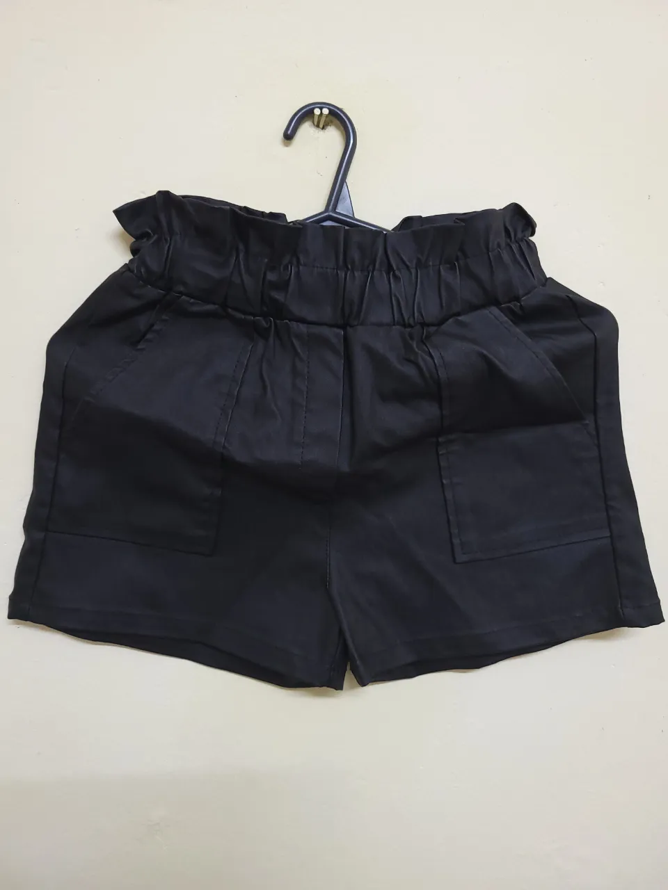 Short negro tiro alto con cintura elastizada y bolsillos delanteros. Ideal para un look casual y moderno.