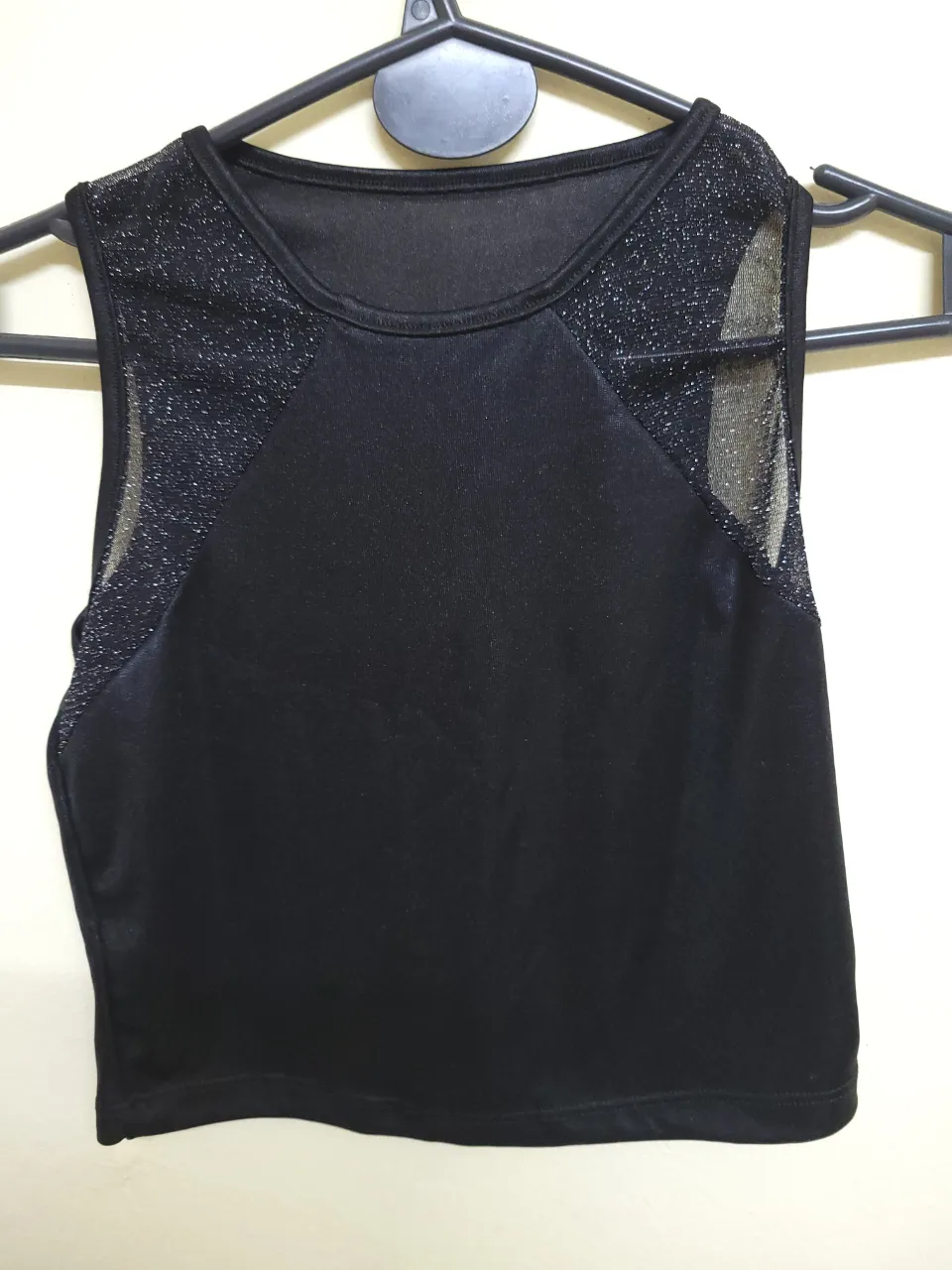 Top  negro con detalles de malla brillante en los hombros. Ideal para salir.